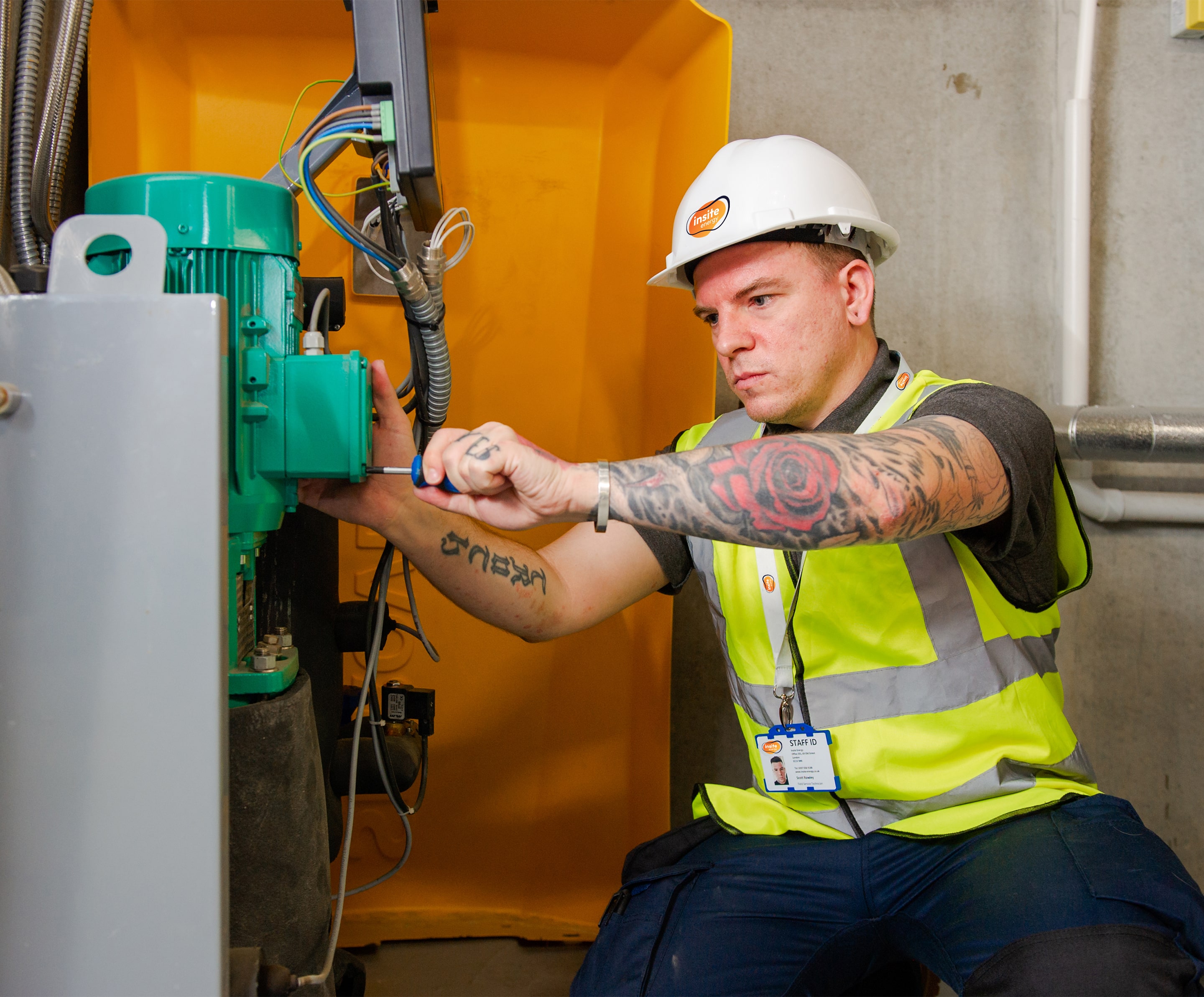 An engineer using a screw driver in a plant room